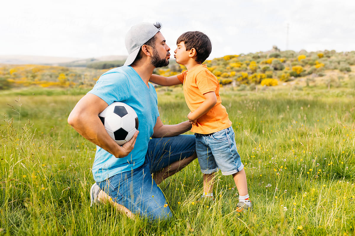 Father kissing his son in the field