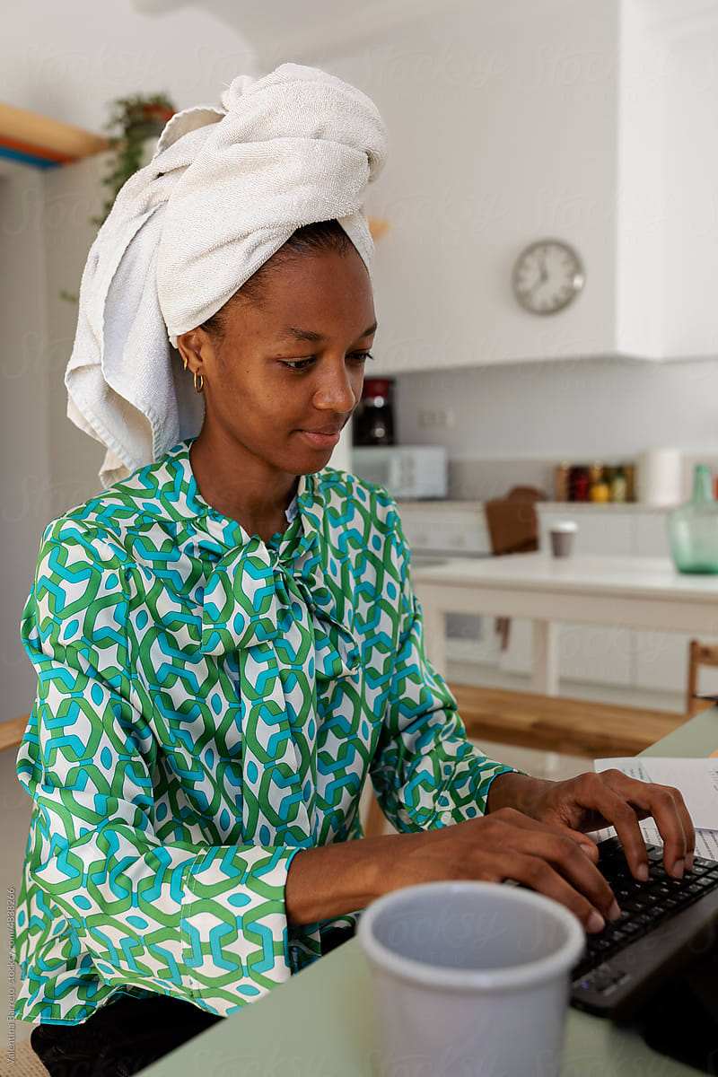 Woman with towel on head working from home