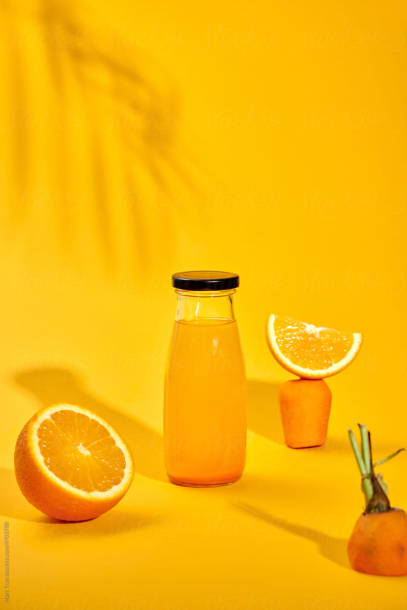carrot and orange fresh juice on yellow table - food and drink