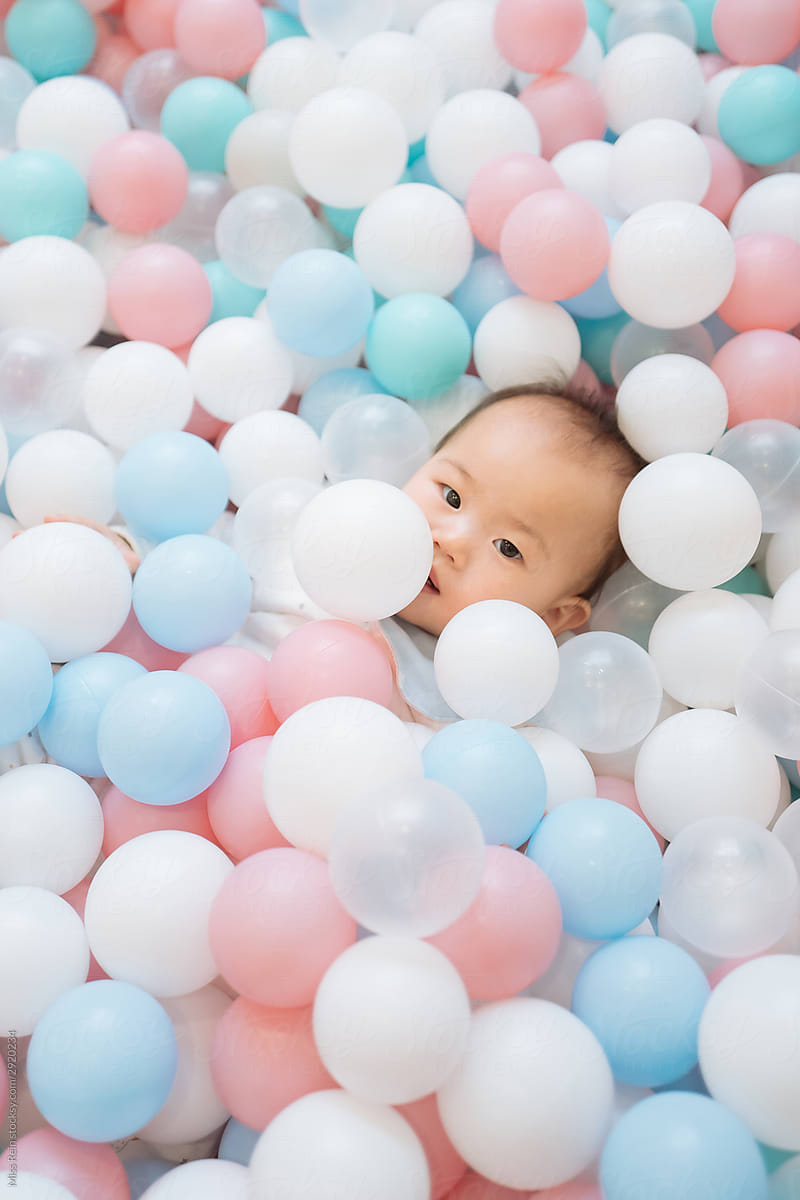 A baby playing with balls