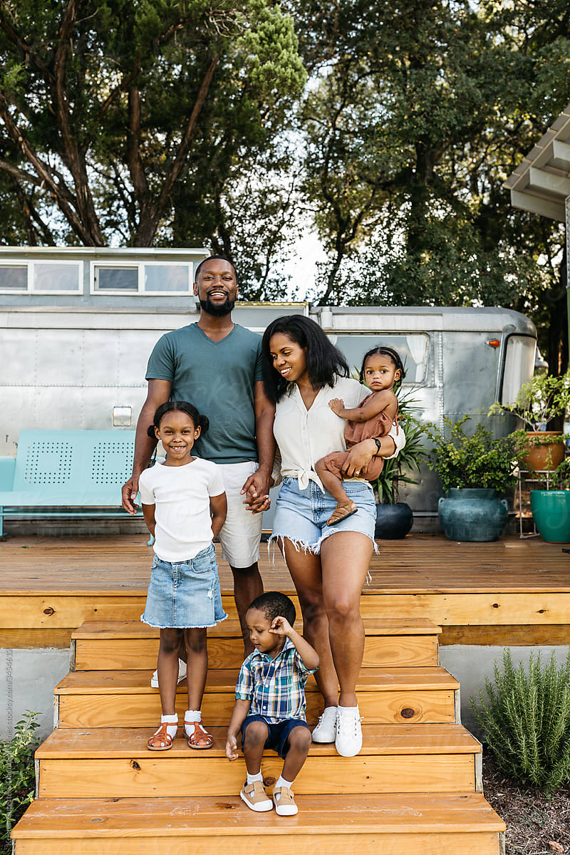 Portrait of a beautiful African American family standing outside in-front of a camping trailer.