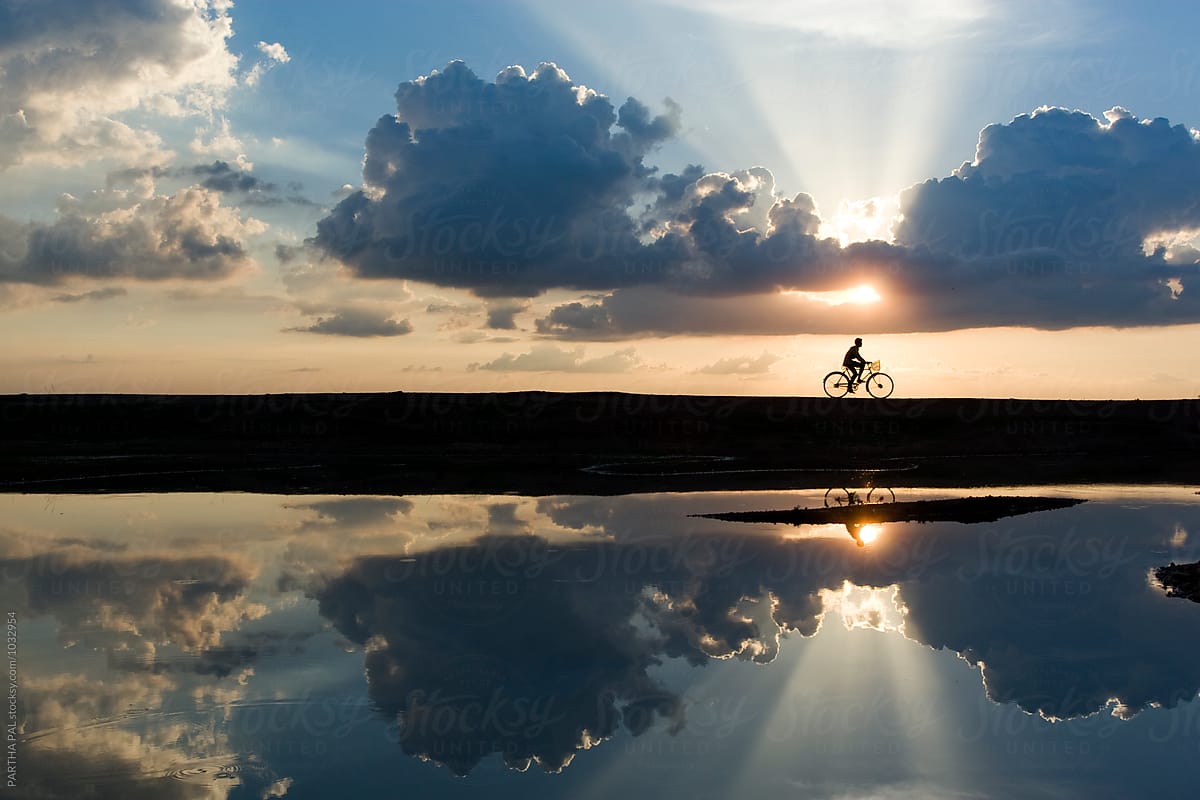 cycling in a countryside with beautiful sky and reflection in water