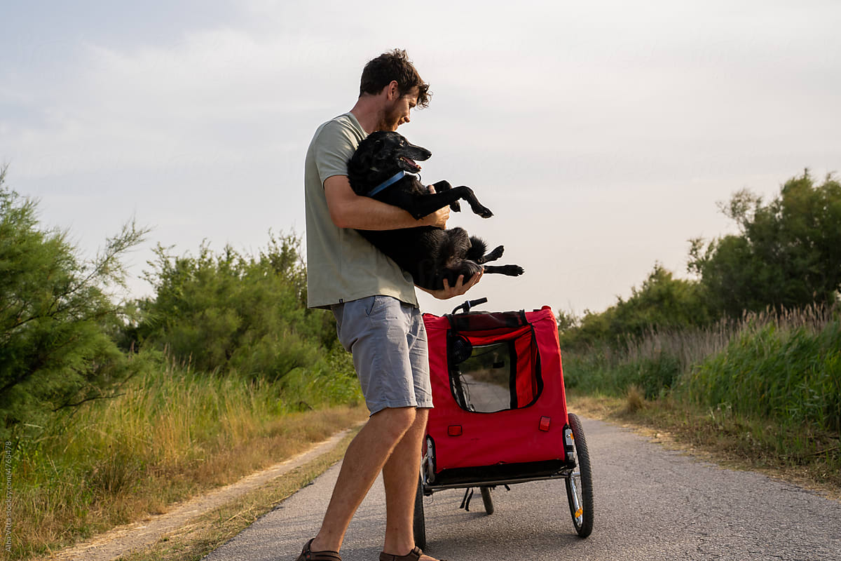 Man going for a bike stroll with dog trailer carrying dog