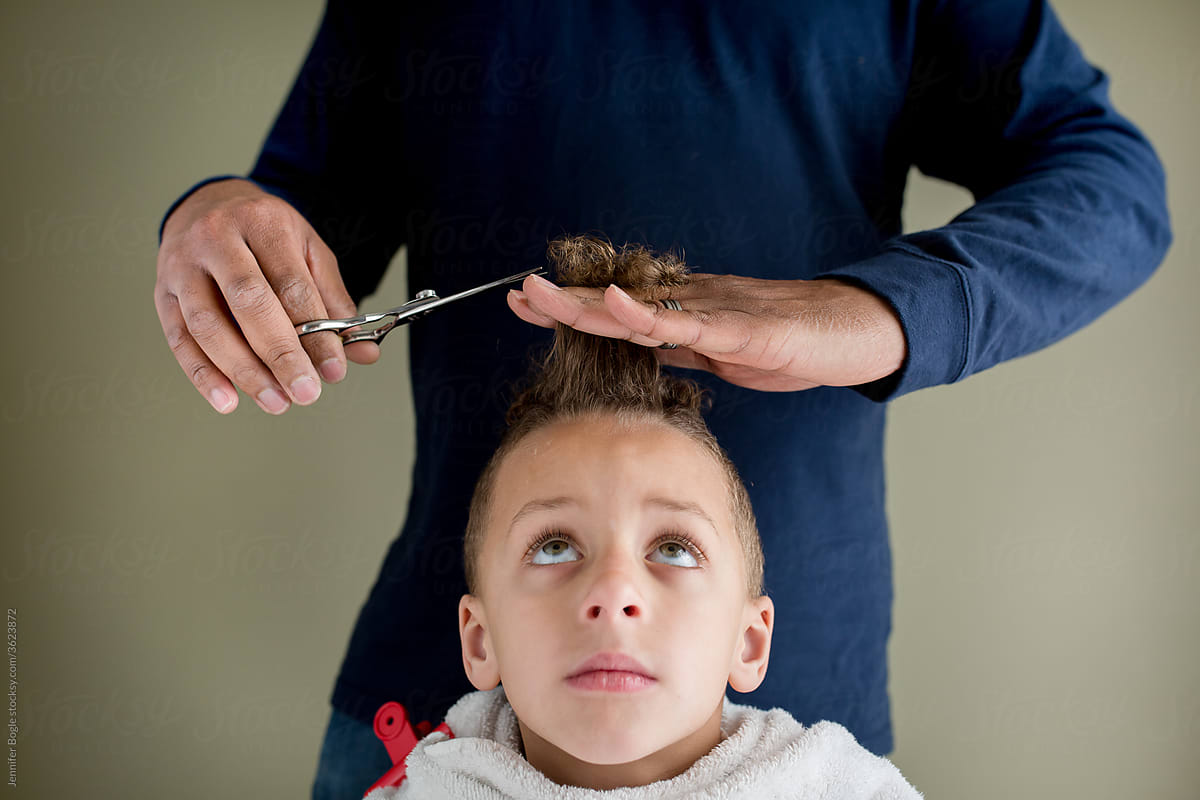 Father trims son\'s hair at home