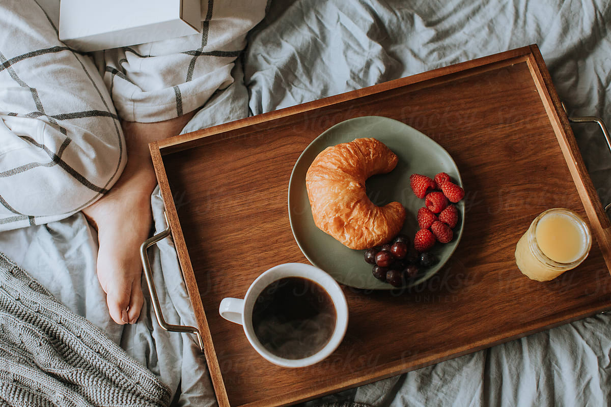 Cozy Bed with Coffee, Pastry, and Juice on Tray