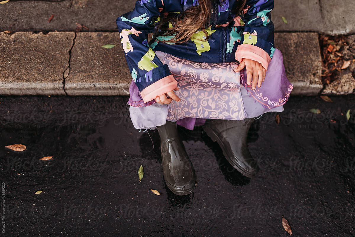 Girl playing sitting on sidewalk
