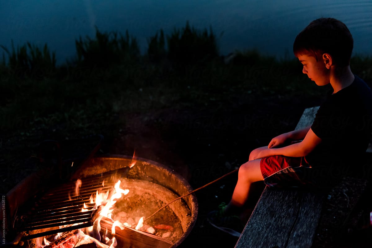 kid grilling marshmallows on campfire