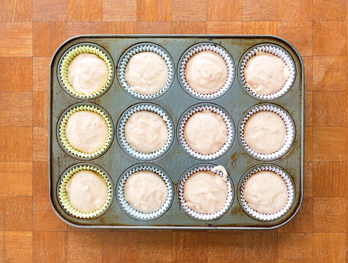 Muffin tin and pastel liners filled with cupcake batter