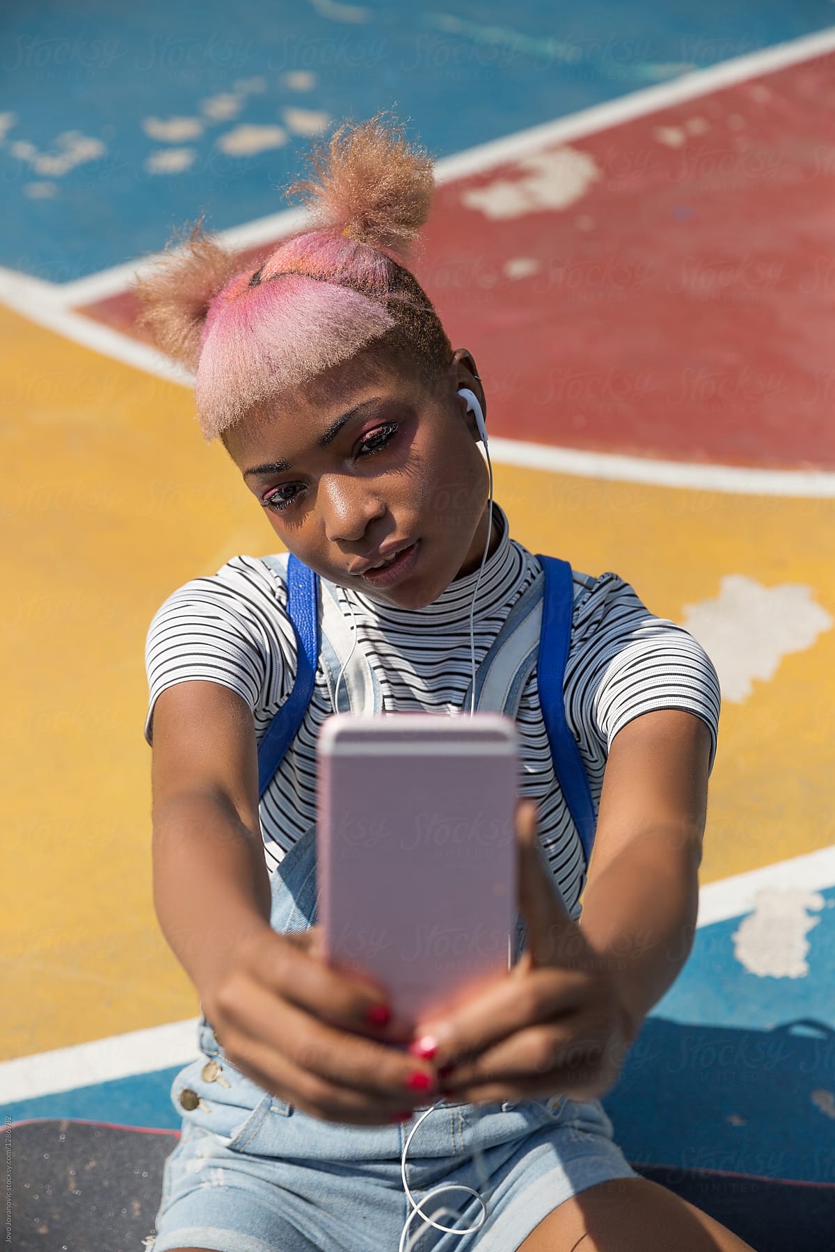 Young woman with pink hair taking a selfie