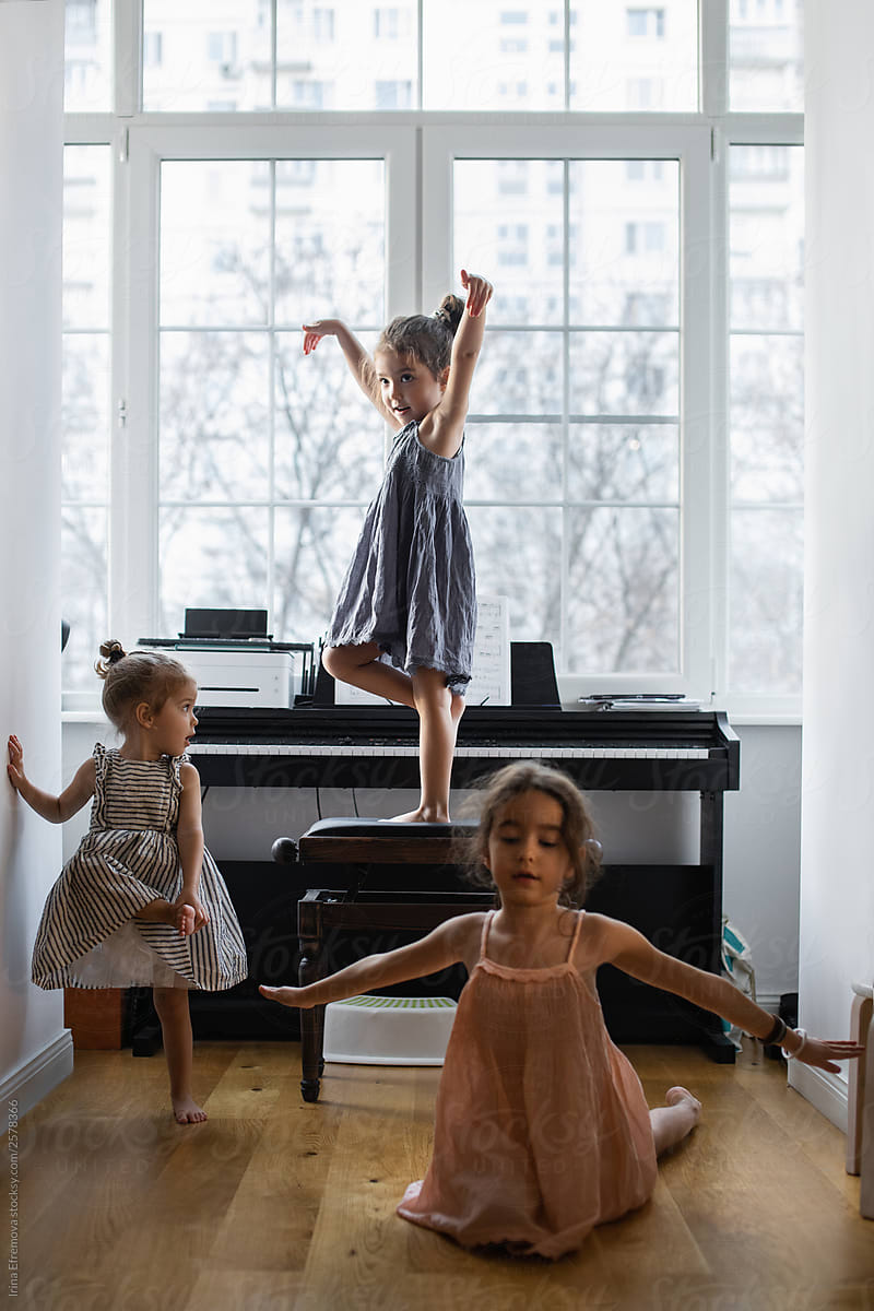 Little girls dancing around the piano