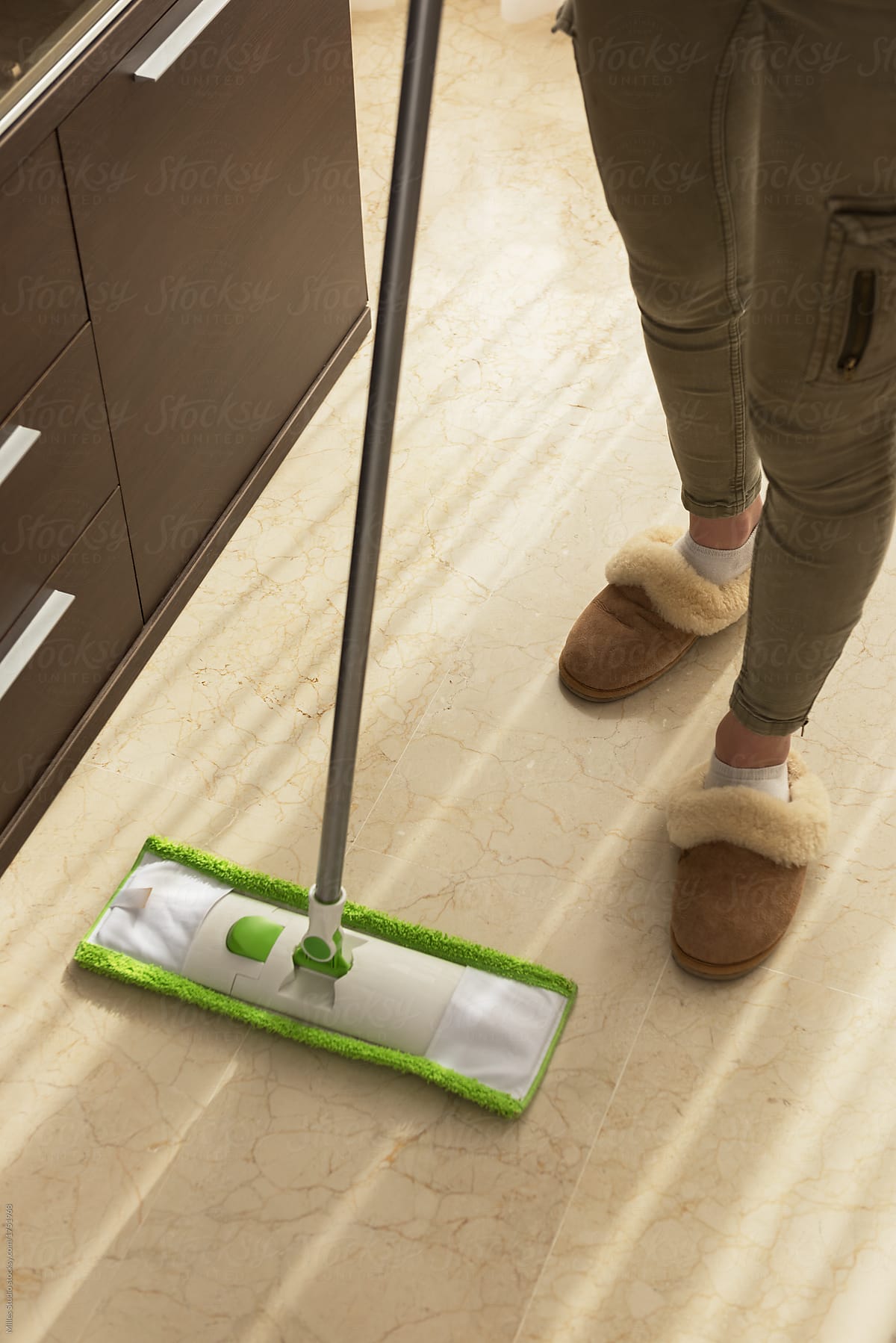 Crop woman mopping floor
