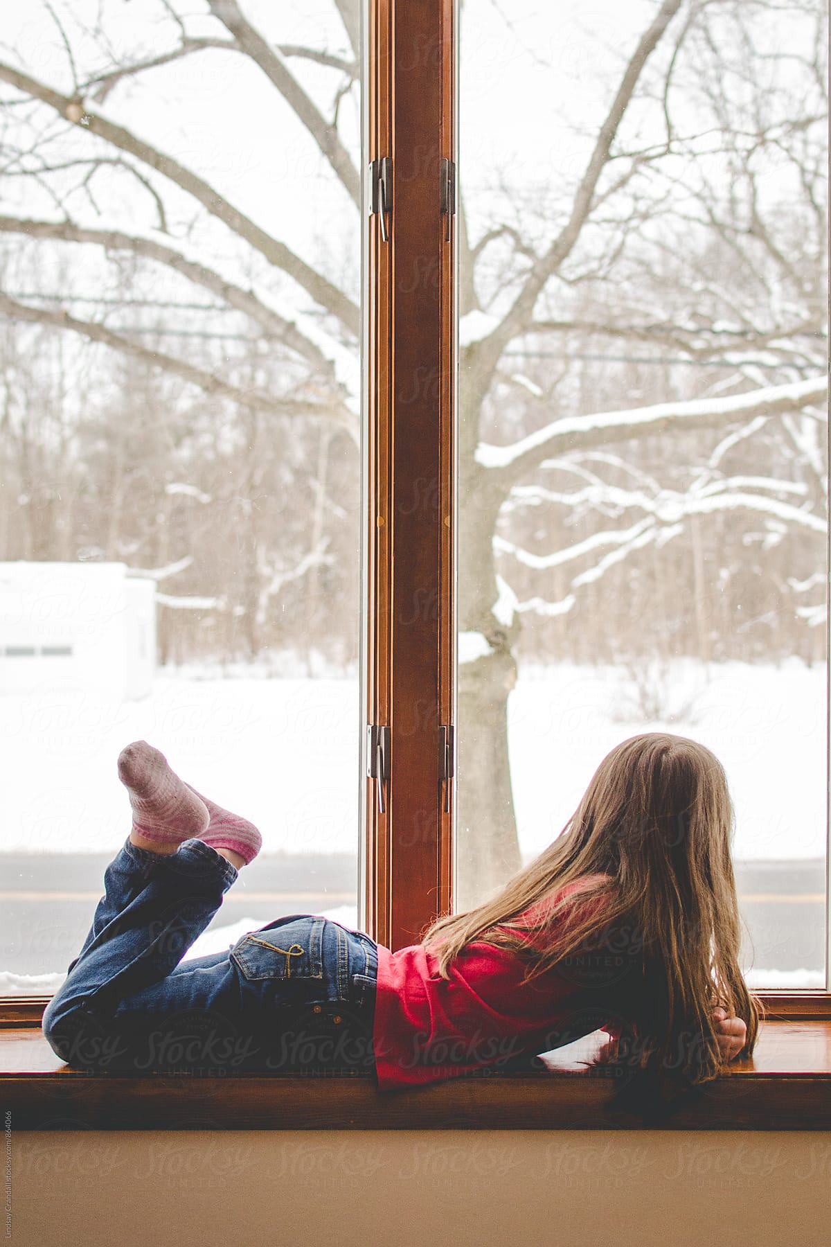 Girl lying beside a snowy window