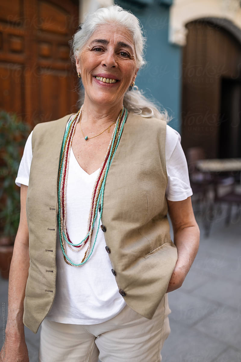 portrait of mature white-haired woman smiling on the street