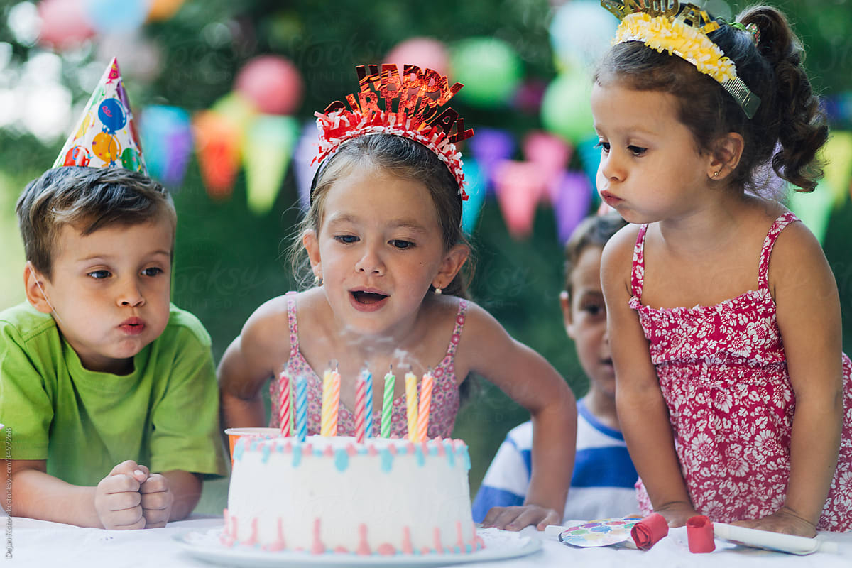 Smiling little girl blowing candles
