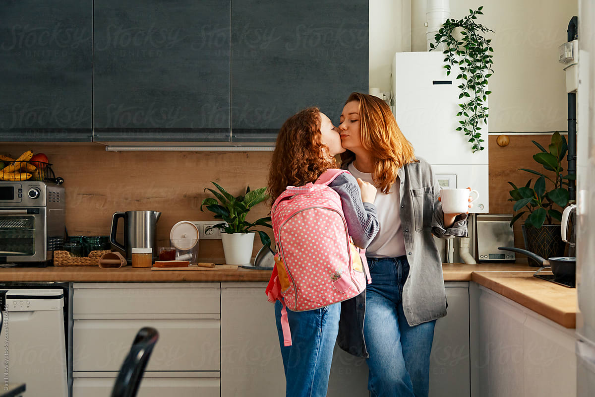 Daughter kissing mother before going to school