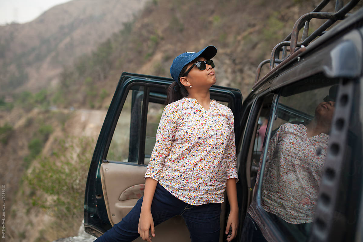 Teen girl wearing sunglasses with car vehicle