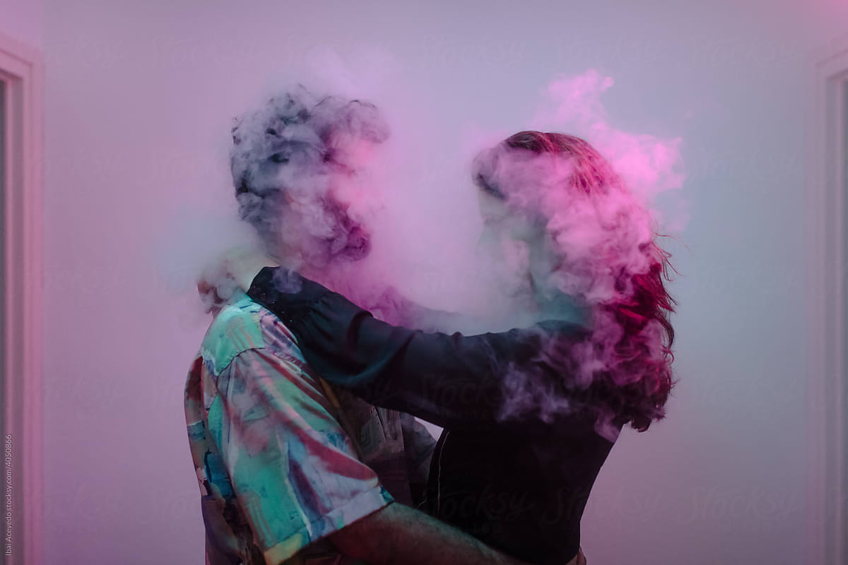 Unrecognizable couple dancing inside a smoke cloud