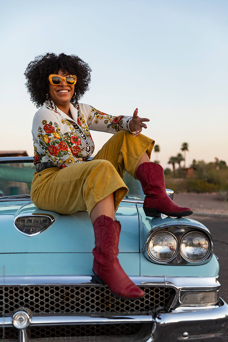 Engaging  Black Woman next to Vintage American car