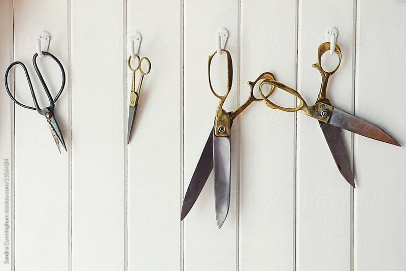 A collection of antique scissors on hooks