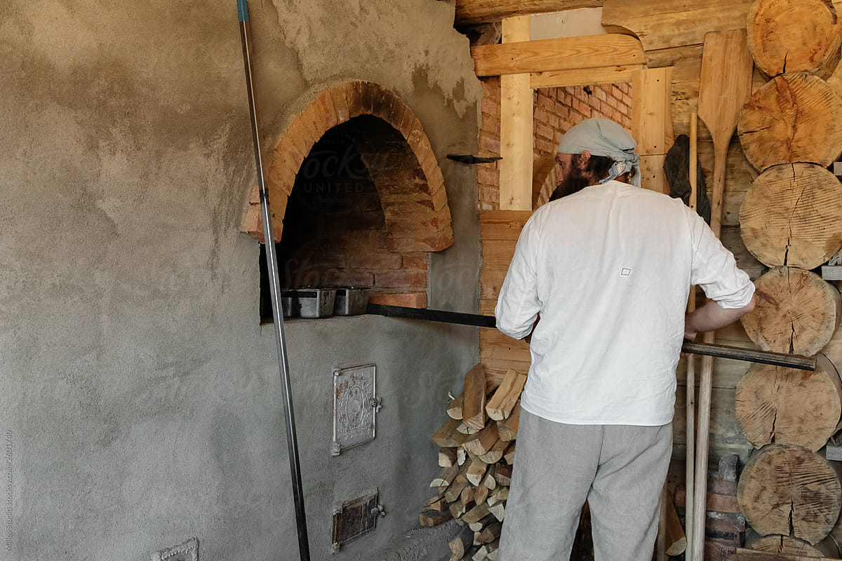 Man placing forms with dough in stove