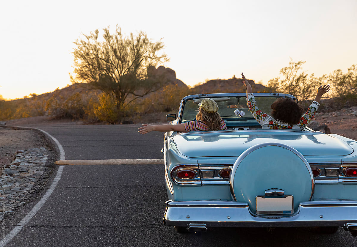 Two Beautiful Girls on Desert Road trip driving down road