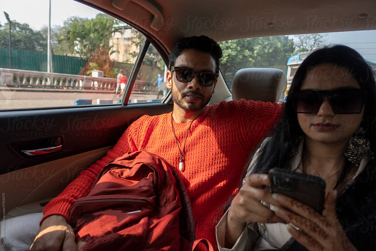 Indian young couple travelling in a car at urban city