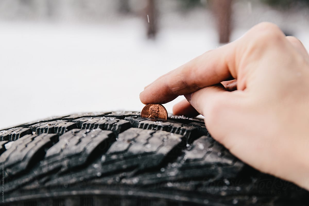Using a penny to check the tread on a snow tire.