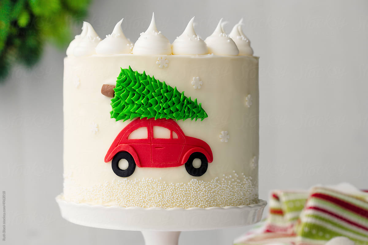 Christmas cake with red car carrying a Christmas tree
