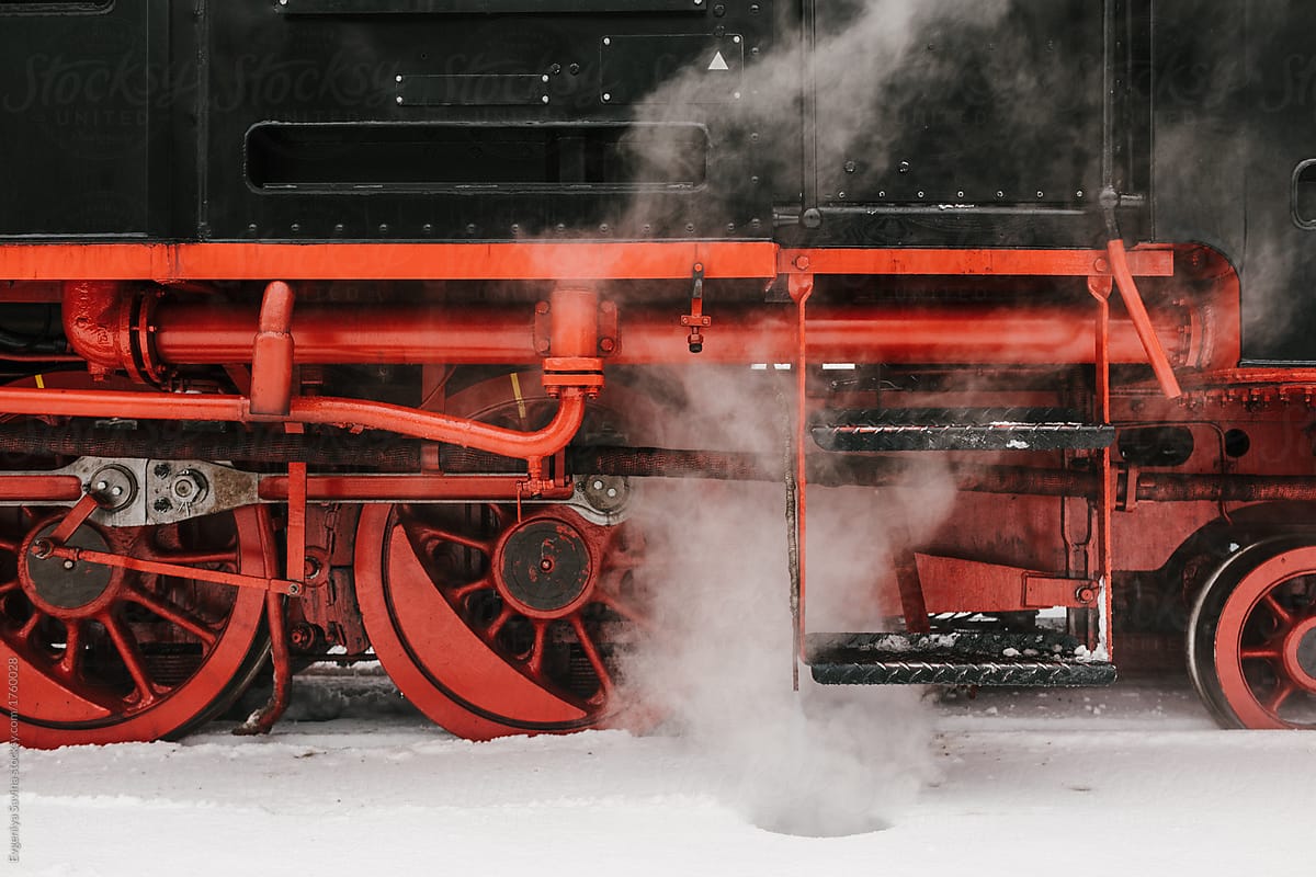 Steam train riding through winter forest