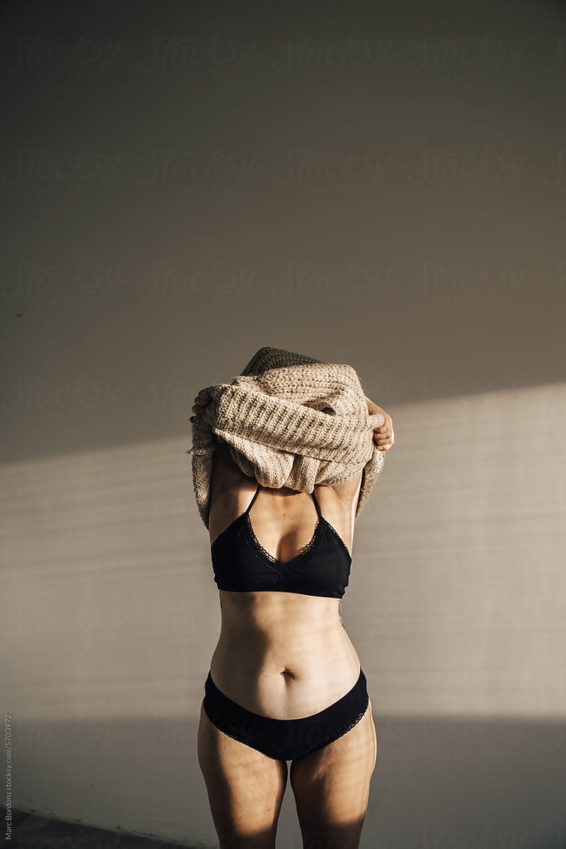 a woman taking off a sweater.