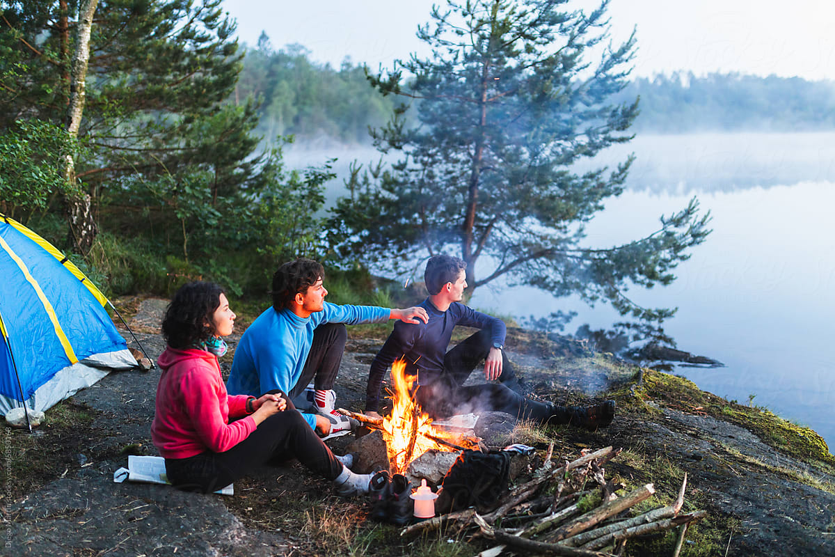 Friends around a lake campfire.