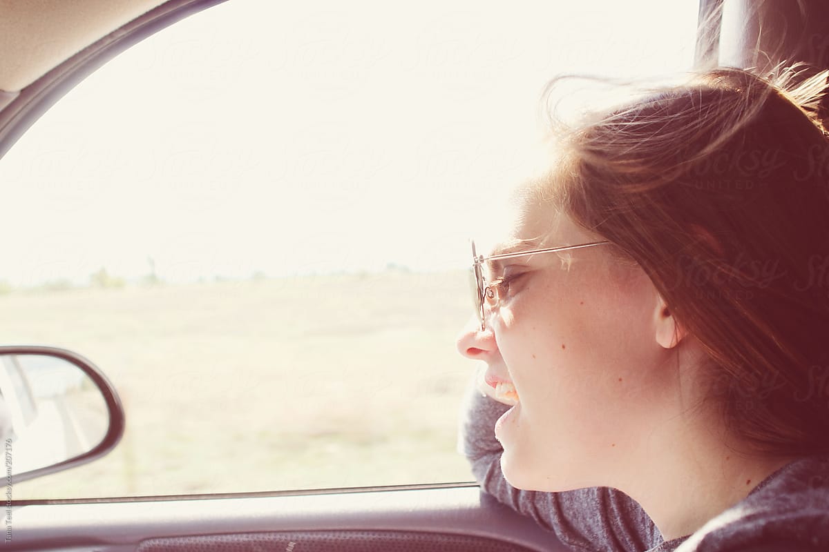 A teenage girl sings in the car