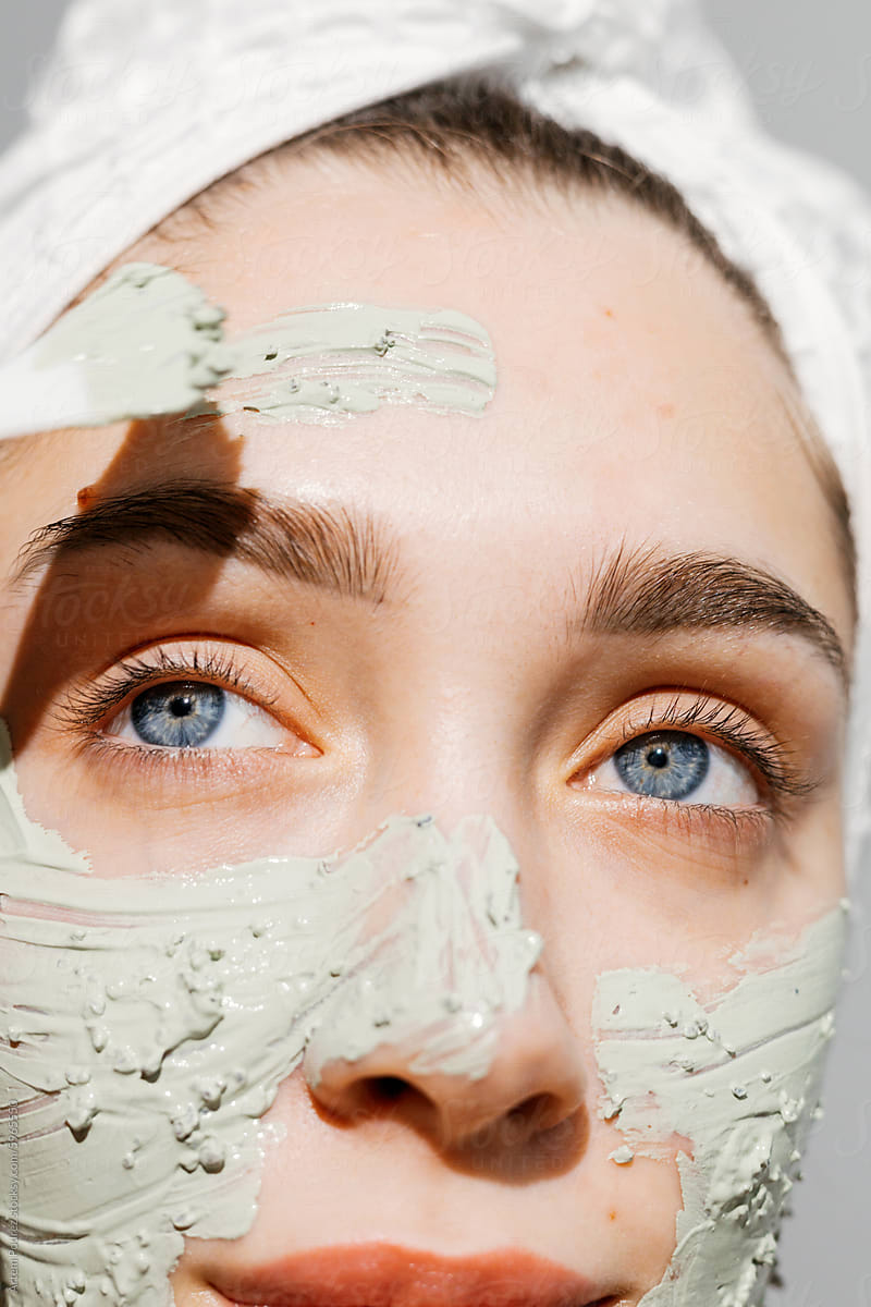 Close-up Portrait Woman applies  Detoxifying Green Clay Mask Routine