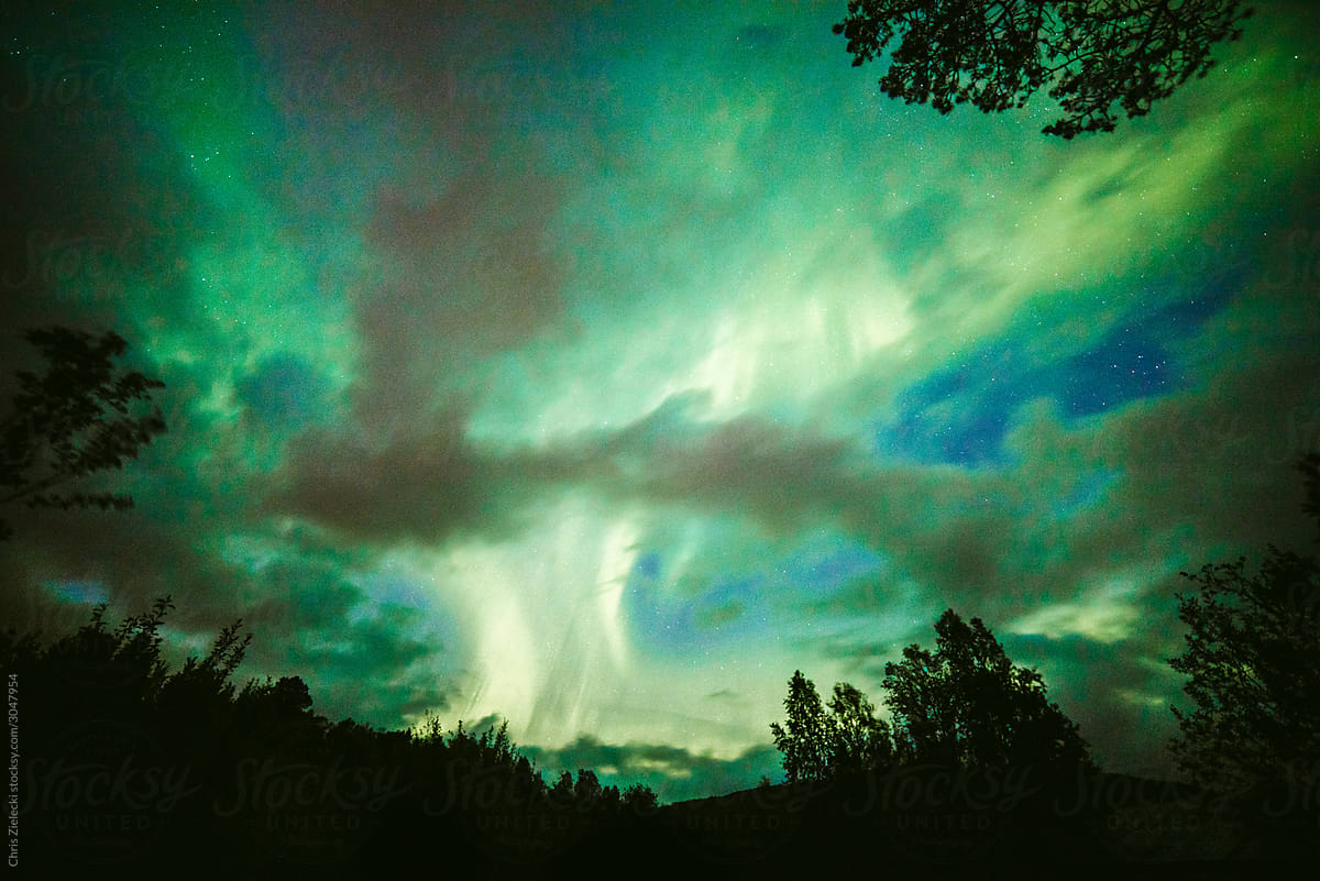 Amazing multicolored cloudy sky with Northern Lights at night