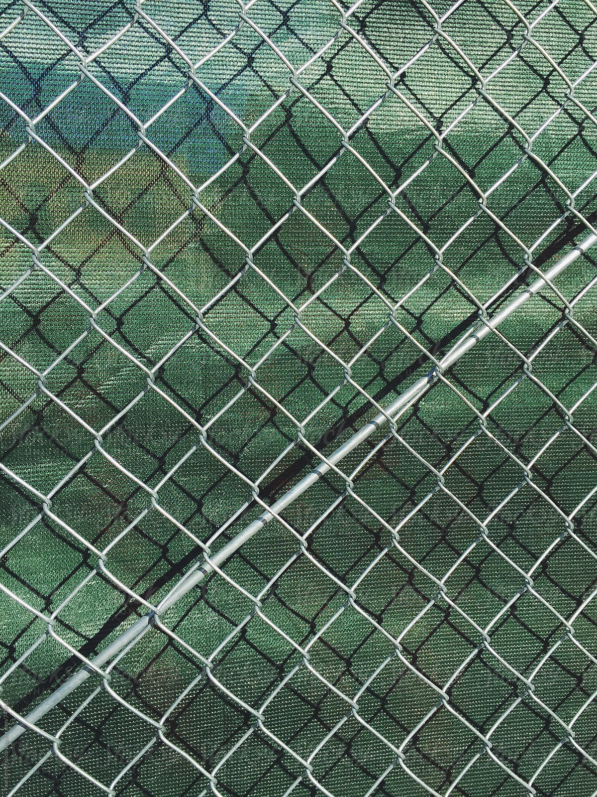 Detail of chain link fence and green fabric at construction site