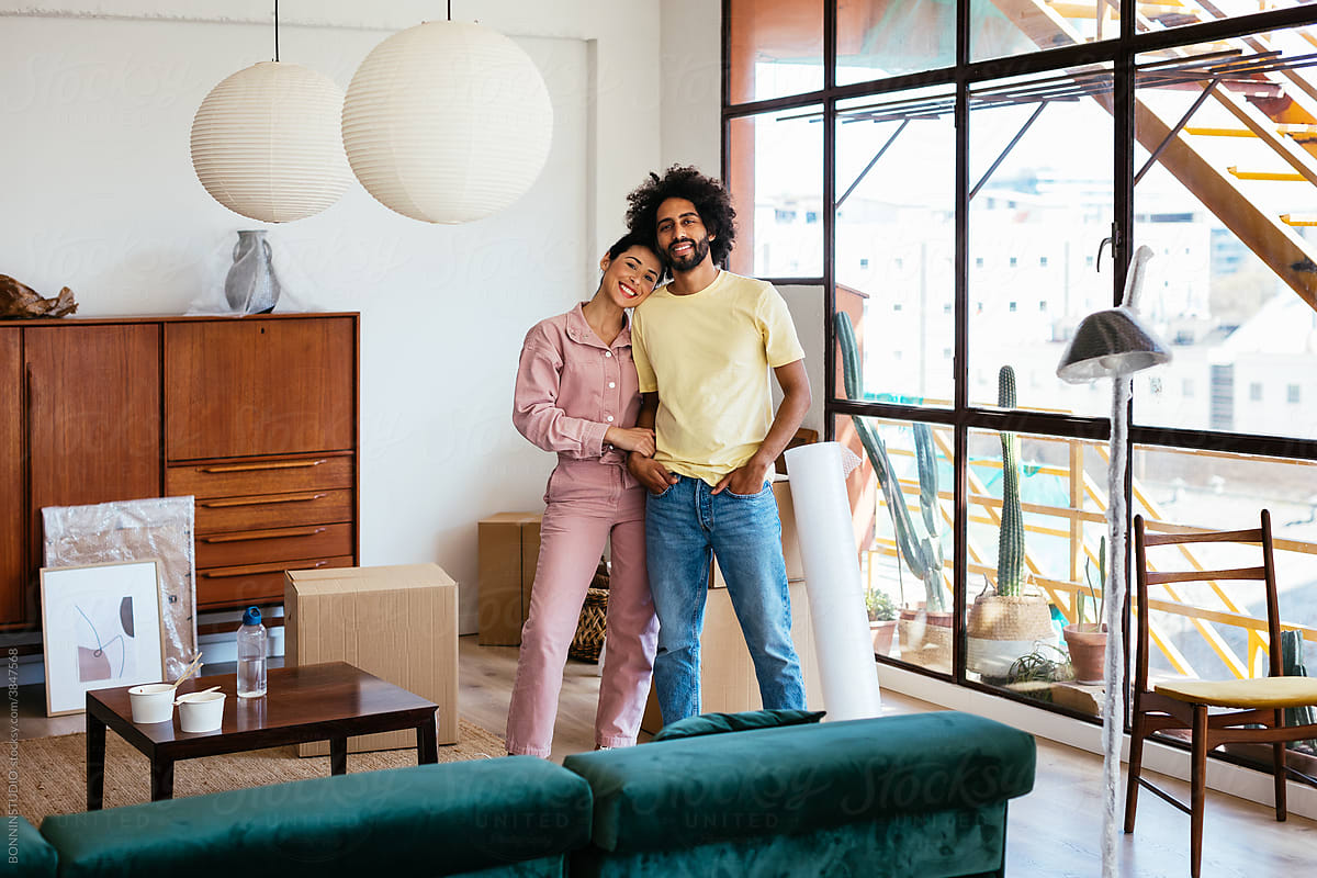 Multiracial couple standing in living room during relocation