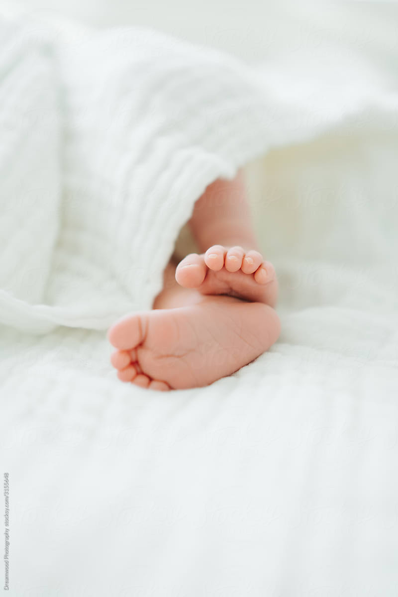 Little feet of baby sleeping in bed