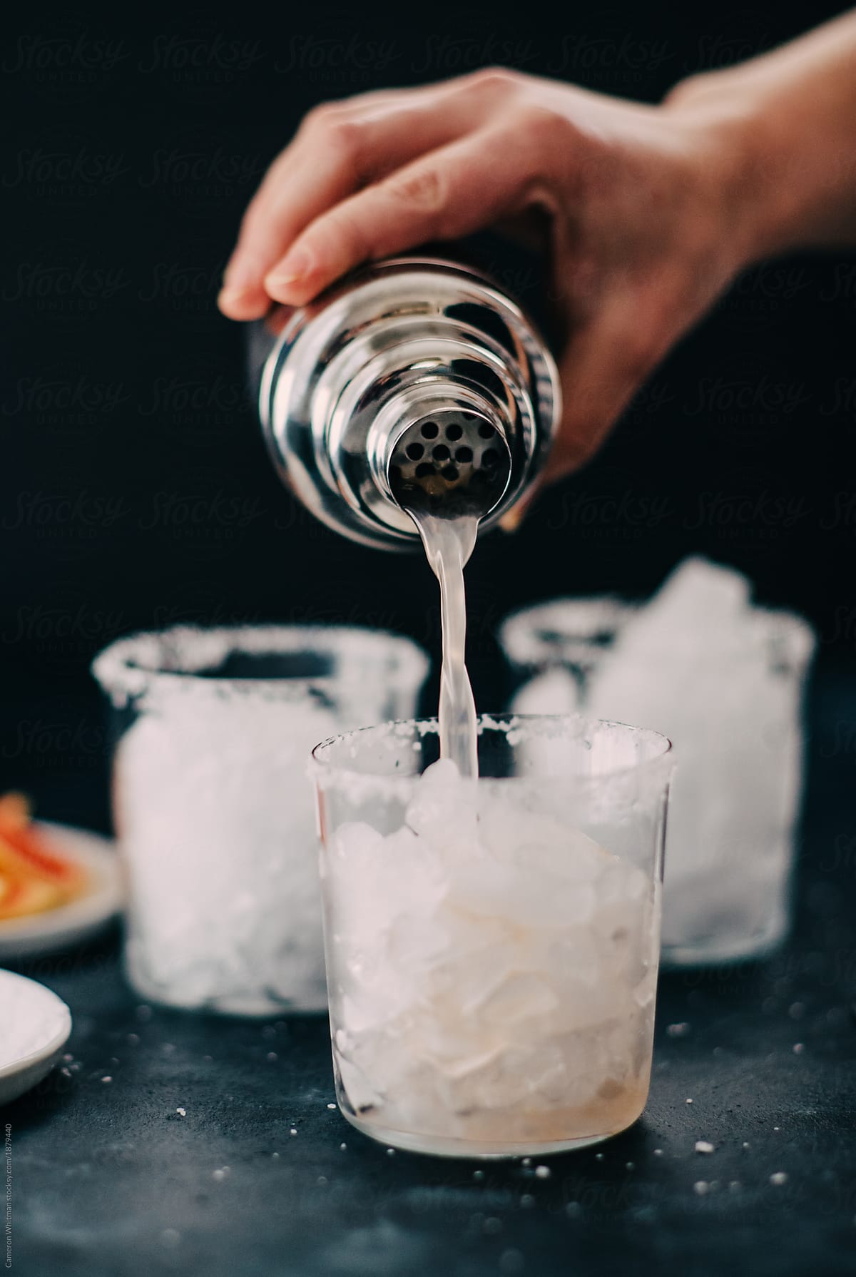 Pouring a Paloma cocktail into a glass