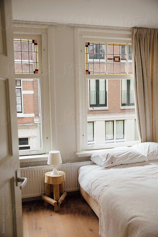 Cozy white bedroom in an apartment overlooking another old apartment in Amsterdam