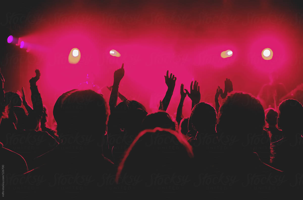 Audience at a live concert under pink spot lights