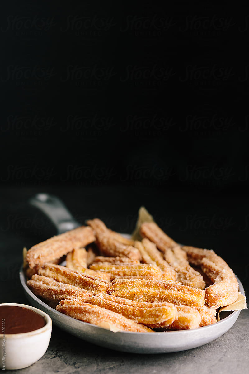 Skillet of churros with chocolate sauce and copy space