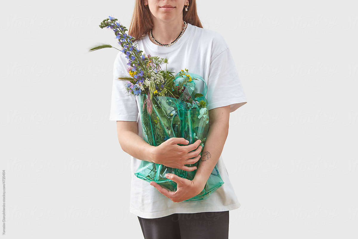 Girl with flowers in recycled bag.