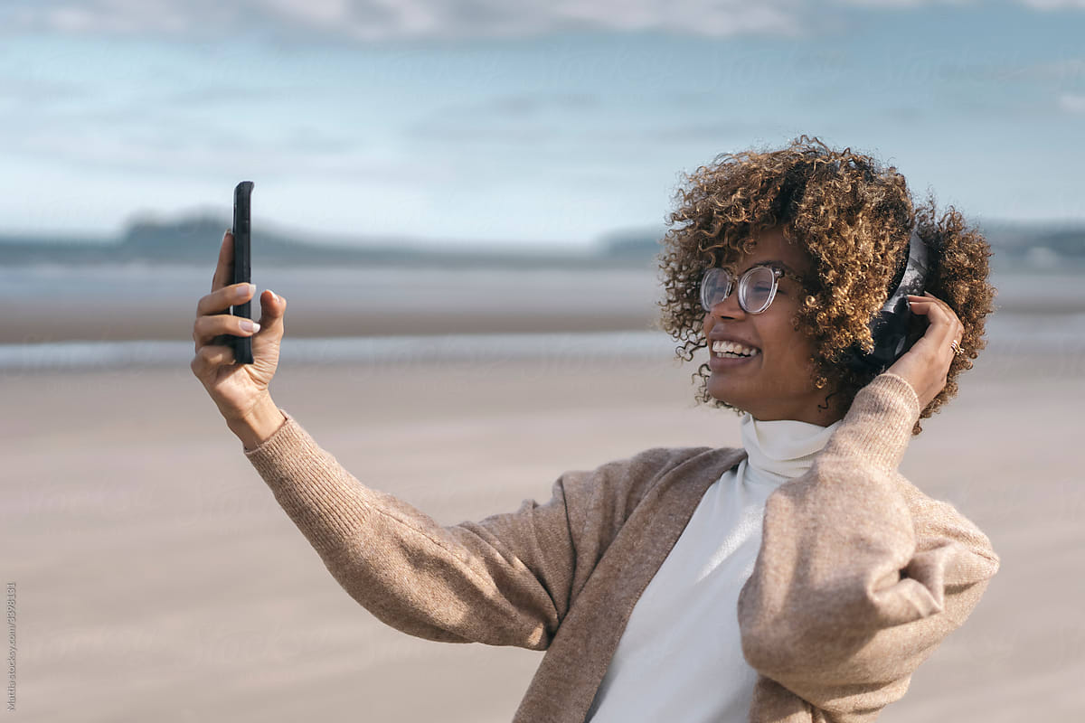 Black Woman Uses a Mobile Phone on the Beach