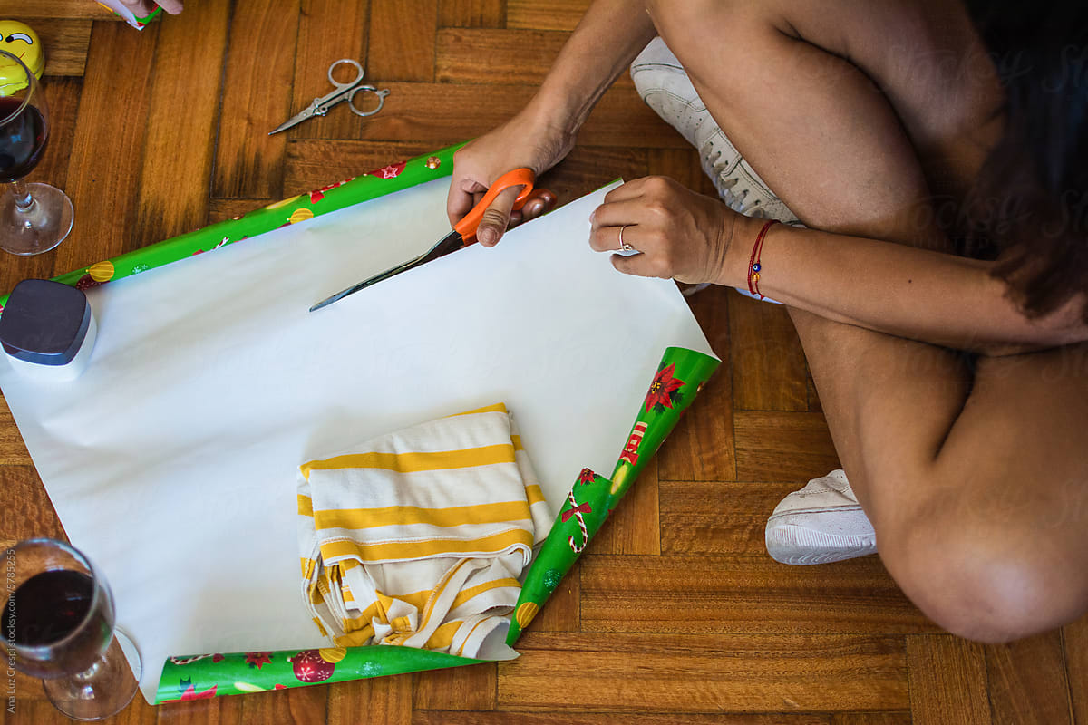 Woman cutting gift paper wrapping in holiday season