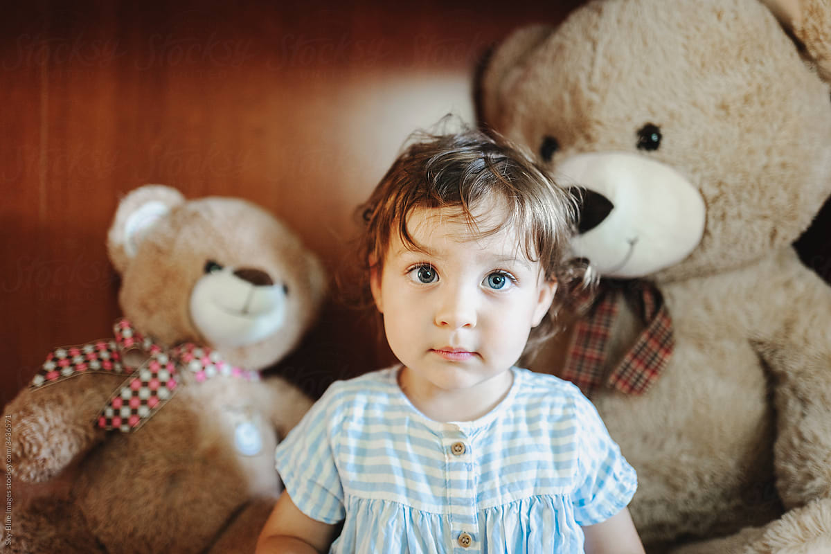 Toddler surrounded by teddy bears