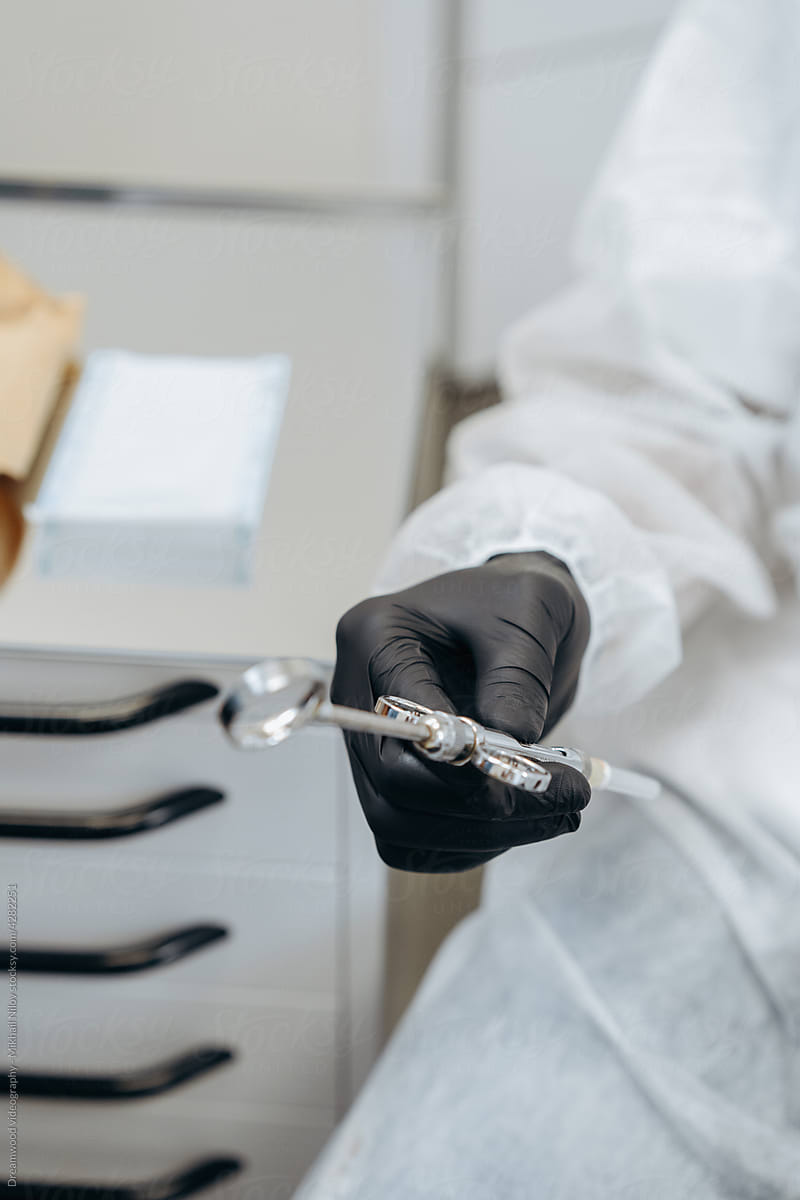 Hand of dentist holds dental high speed turbine