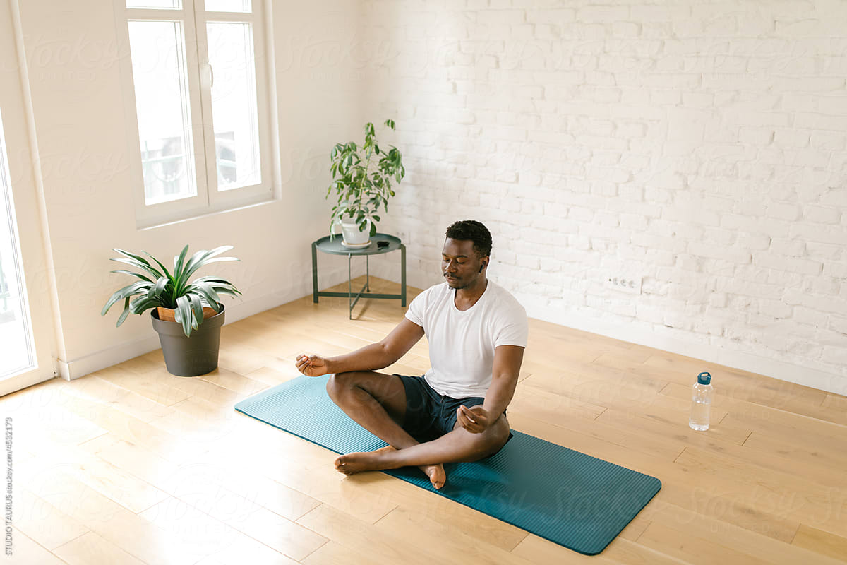 Millennial man practicing calm yoga indoors