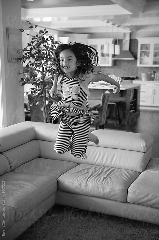 Little Girl Jumping Off Couch