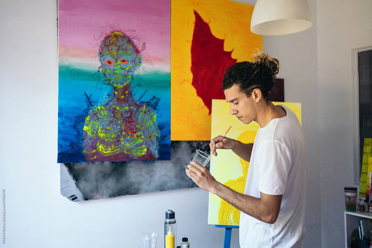 Young artist preparing paint to work on a picture on canvas