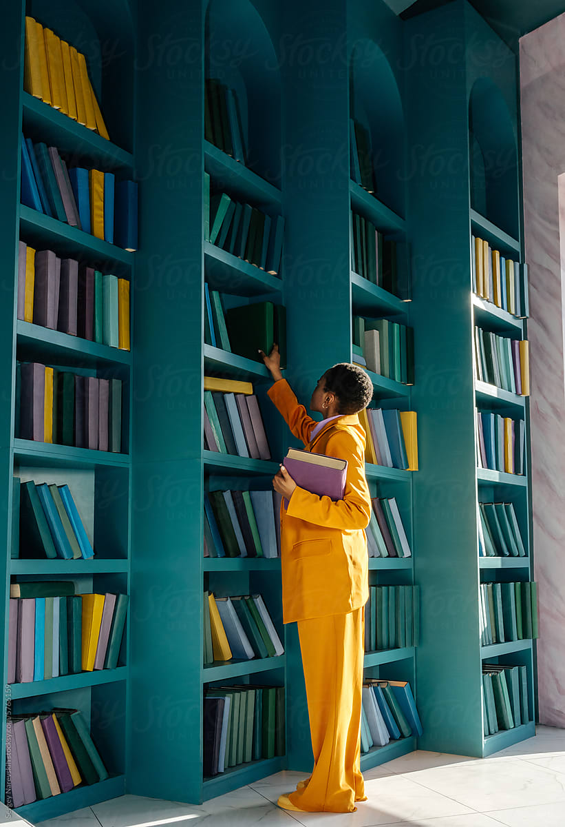 Woman in yellow outfit picking books